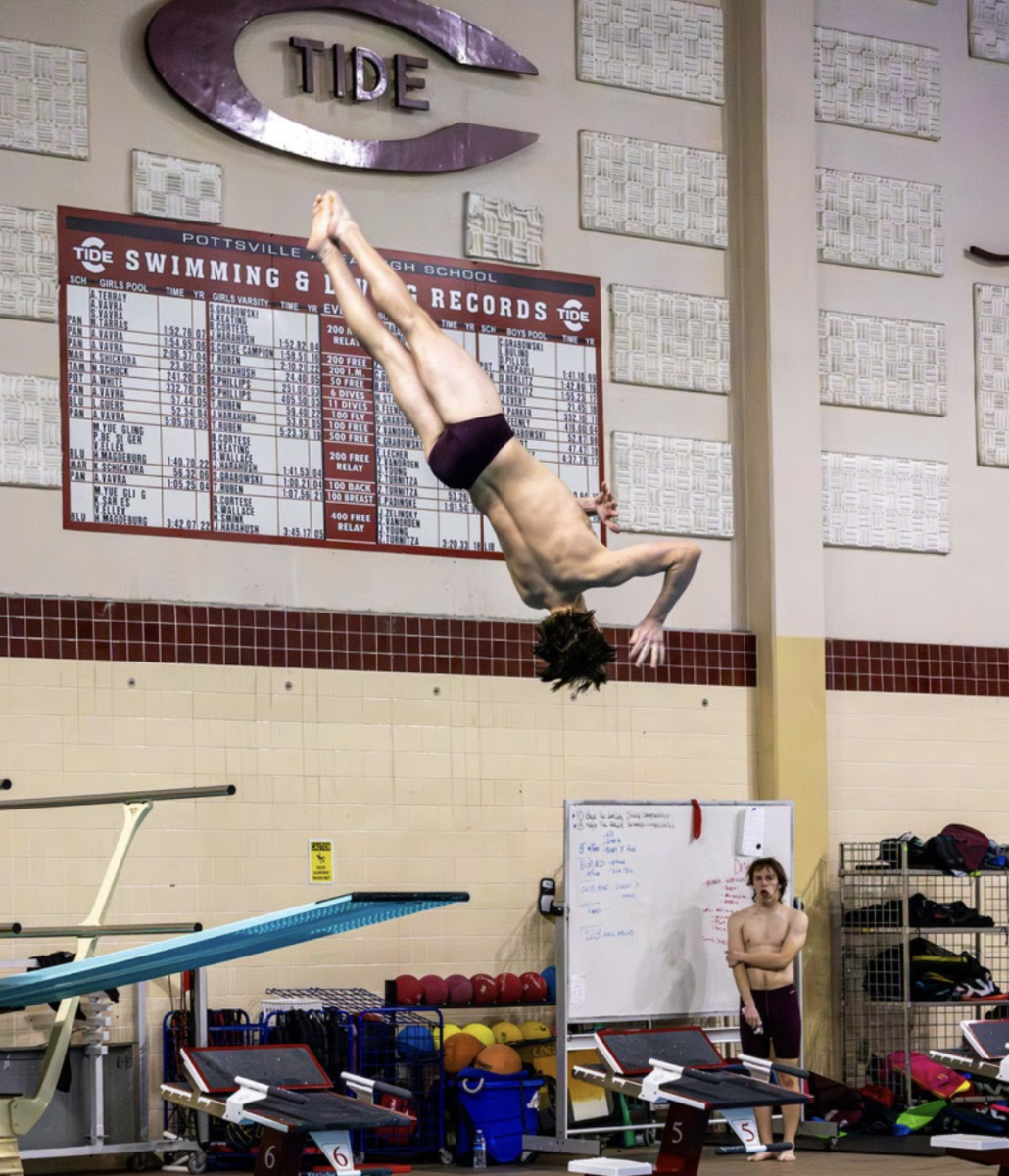 Adam Klinger dives in a meet against Marian Catholic. He won this meet and once again set a new school record. “It’s such a surreal moment hearing everything go silent and hitting the surface and then coming up and hearing everyone cheering so loudly,” he said.
